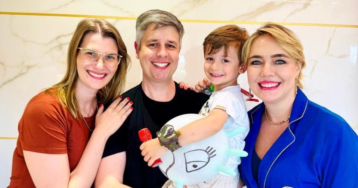 Família sorridente — pai, mãe e filho pequeno — posando ao lado da Dra. Vanessa Nani na clínica Prime Saúde Oral em Alphaville.