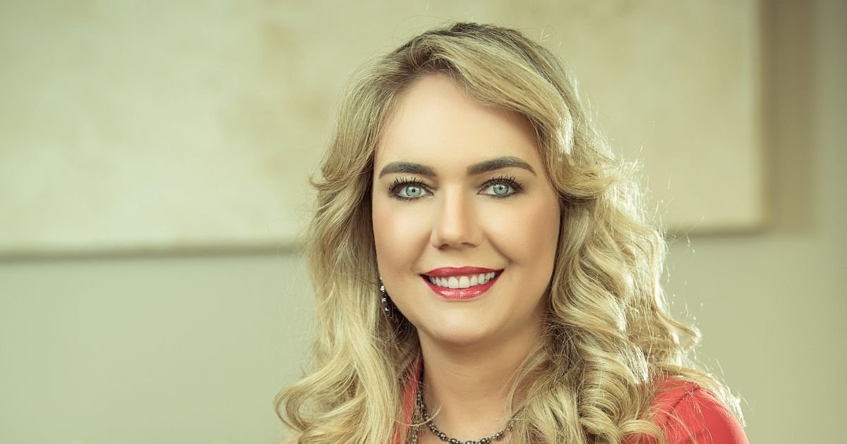 Dra. Vanessa Nani analisando o planejamento digital de um sorriso em um tablet para decidir entre o uso de lentes ou facetas.