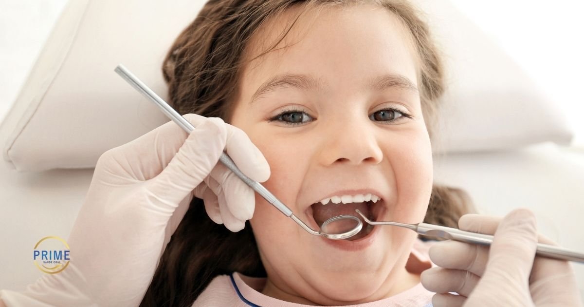 Menina de boca aberta sendo atendida por dentista com luvas brancas utilizando instrumentos de exame, com expressão tranquila e cooperativa na cadeira odontológica, com logo da Prime Saúde Oral