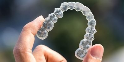 Pessoa segurando alinhador transparente Invisalign na Prime Saúde Oral
